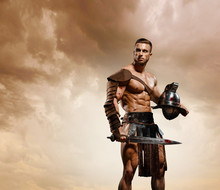 Gladiator Fighting On The Arena Of The Colosseum On Dramatic Light. Roman Hoplomachus Armed Fighter Concept Historical Photo