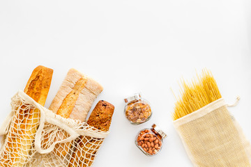 Wall Mural - Eco bag, glass jars on white background, top view. Zero waste food storage concept copy space