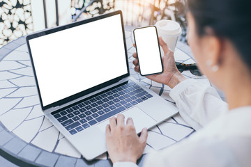 Wall Mural - computer,cell phone mockup image blank screen with white background for advertising text,hand woman using laptop texting mobile contact business search information on desk in cafe.marketing,design