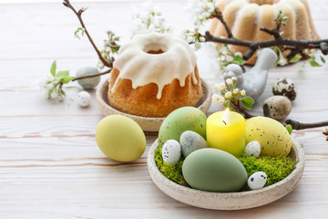 Easter table decorations with eggs, moss and ceramic figurines.