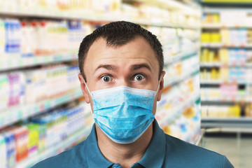 Wall Mural - A surprised man wearing a medical mask amid a supermarket counter. Concept on store price increases during quarantine due to coronavirus pandemic