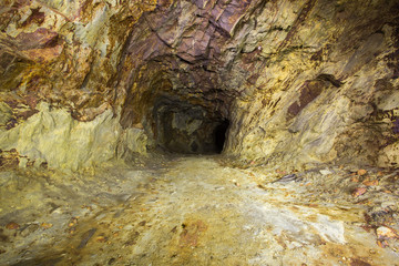 Abandoned copper ore mine underground tunnel with yellow dirt