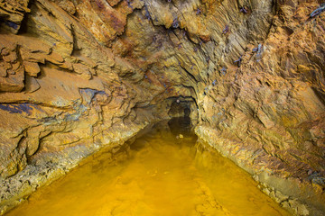 Abandoned copper ore mine underground tunnel with yellow dirt