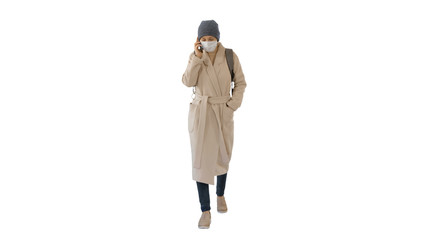 Young woman in protective mask walking and talking by mobile pho