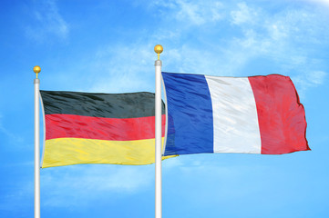 Sticker - Germany and France two flags on flagpoles and blue cloudy sky