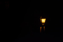 Streetlight Lit In The Dark Of The Night Emitting A Very Orange Light