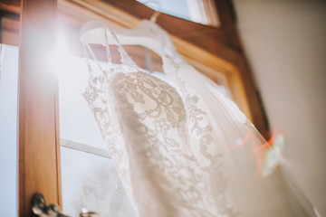 Sticker - White elegant fashionable bride dress hanging in bright room