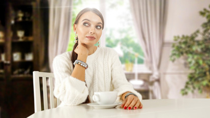 Wall Mural - Slim young woman with cup of coffee or tea and white wooden table in home interior with window 