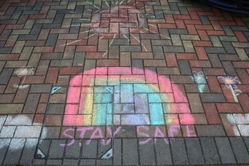 A beautiful rainbow drew by children on the street during the covid-19 quarantine. Kids are drawn. Coronavirus disease lockdown. Positive attitude and desire for hope. London, United Kingdom, UK.