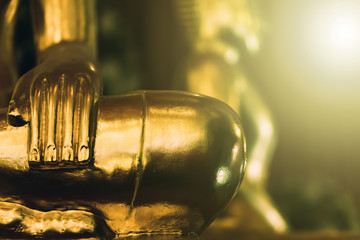 Wall Mural - Background buddha face head body hands in buddhist temple with isolated wall. Thai old woman pray for good luck, zen peaceful and holy meditation relax. Gold statue in Thailand temple to worship