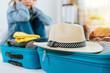 © Vittaya_25 - focus vintage hat on suitcase with woman hipster traveler sad after flight cancelled with packing clothes into suitcase for vacation at home, delayed flight, summer holiday, backpacker, travel concept