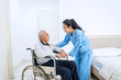 © Creativa Images - Man sitting on wheelchair with nurse in bedroom