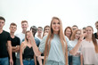 © ASDF - young woman standing in front of a casual group of young people