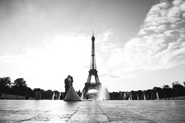 Happy romantic married couple hugging near the Eiffel tower in Paris