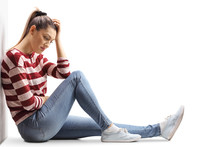 Sad Young Woman Sitting On The Floor With Head Down