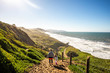 © Adam Hester - A young girl and her mother hiking together on a sunny day near the Pacific Ocean with warm clothes.