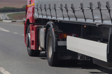 Poster - large truck moves along the road.