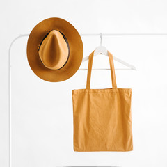 Wall Mural - Brown hat and eco bag on hanger on white background. Minimal concept.