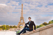 © Aleksei Zakharov - A man against the backdrop of the Eiffel tower in Paris, France.