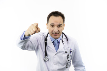 Wall Mural - Middle-aged angry doctor in white coat and stethoscope annoyed and frustrated shouting with raised hand pointing finger to you, isolated white background, medical warning, threat concept