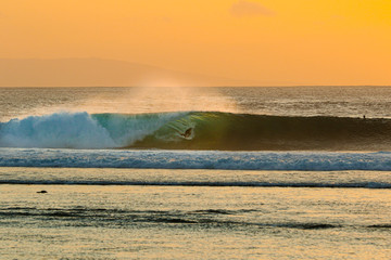 Wall Mural - view of man surfing in sea during sunset