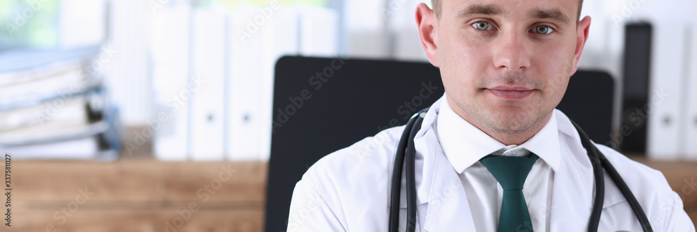 Handsome smiling male doctor stand in office looking in camera portrait ...