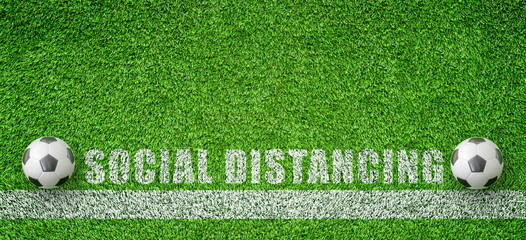 Wall Mural - CORONA Virus and Social Distancing Concept : Two soccer balls put on green artificial grass that keeping distance for social distancing campaign.