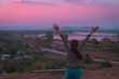 © etemwanich - back side view  hipster girl posing freedom by hand up relaxing with holiday relaxing on the mountain in sunset at Northeast at Chiangkhan of Thailand