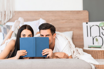 Sticker - Happy young couple reading book in bedroom