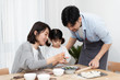 © 浩然 张 - Young Asian mom and dad making dumplings with daughter