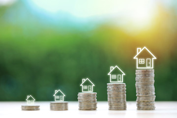 Property investment and saving growth or business financial house mortgage for advertising concept. House on stacking coin on wooden desk with green nature background, meaning of growing or saving .