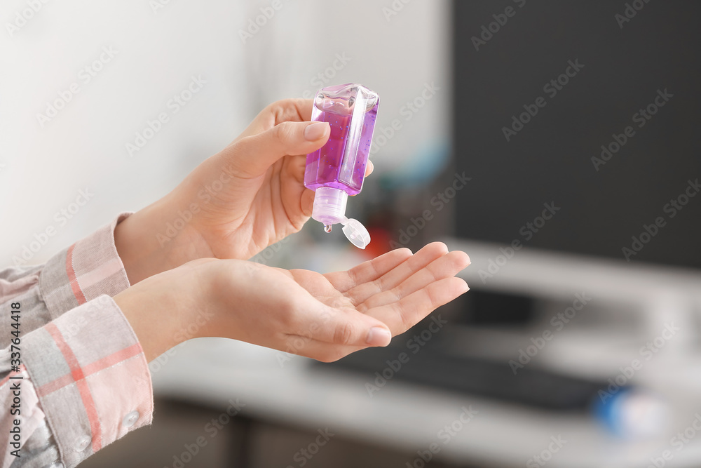 Woman using sanitizer at home