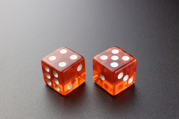 Wall Mural - Two red glass dice on a black matte background with side lighting. Four and five with copy space.