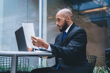 Wall Mural - Confused African American employee looking at documents