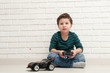© Olga Koronyevska - boy with toy car against a brick wall