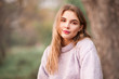 © morrowlight - Beautiful blonde teen girl 16-18 year old wearing knitted sweater posing outdoors over nature background. Looking at camera. Spring season.