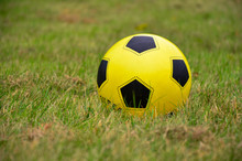 Close-up Of Yellow Soccer Ball On Grassy Field