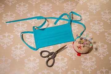 Polypropylene masks, pins and scissors used in home-made clothing to protect people against covid-19