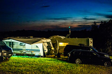 Cars And Caravans On Field Against Sky At Night