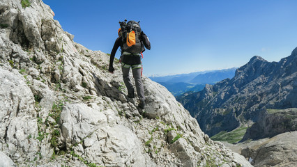 Wall Mural - Tourist with equipment on the via ferrata trail in the alps