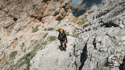 Wall Mural - Tourist with equipment on a mountain trail in the Alps