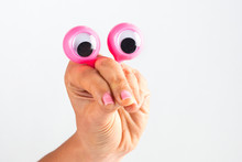 Cropped Hand Of Woman Holding Googly Eyes Against White Background