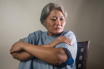 dramatic portrait of attractive sad and depressed mature woman with grey hair in pain suffering ment