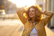 © pikselstock - Portrait of young woman with curly hair in the city