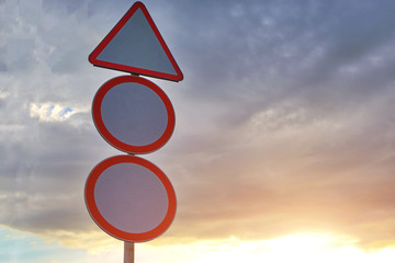 Warning road sign against a cloudy sky with clouds.