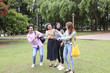 © oqba - Young asian malay chinese man woman outdoor park walk stand study talk discuss point laptop file book backpack