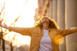 © pikselstock - Portrait of young woman with curly hair in the city
