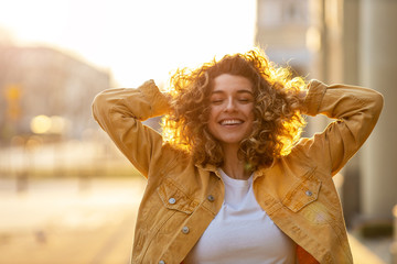 portrait of young woman with curly hair in the city
