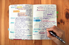 Good Student Taking Notes In A Colorful Marked And Underlined School Notebook - First Person View From Above, With The Hand Writing Holding A Pen