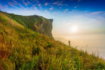 Panorama beautiful landscape nature of sunrise on peak mountain with sun cloud fog and bright sky in winter at Phu Chi Fa Forest Park is a famous tourist attraction of Chiang Rai Province, Thailand